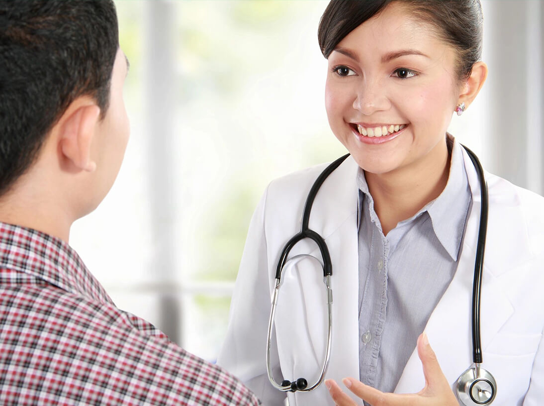 A woman in white coat talking to a man.